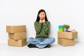 Young chinese woman moving to a new home doubting between two options.