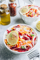 Spring healthy vegan salad with raw beet, carrot and cabbage in white bowls. Alkaline Diet concept. Selective focus