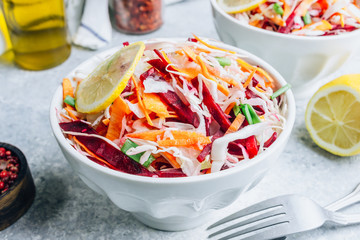 Spring healthy vegan salad with raw beet, carrot and cabbage in white bowls. Alkaline Diet concept. Selective focus