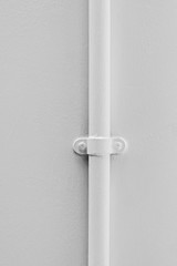 Seamless white pipe attached to a clean whitewashed wall background.
