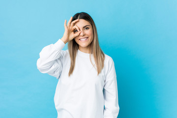 Fototapeta premium Young caucasian woman isolated excited keeping ok gesture on eye.