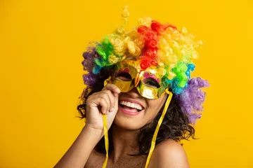 Deurstickers Mooie vrouw gekleed voor carnaval nacht. Glimlachende vrouw klaar om te genieten van het carnaval met een kleurrijke pruik en masker © Brastock Images