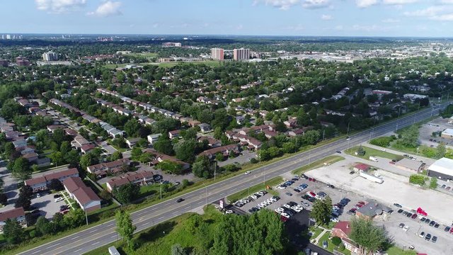 Diagonal Road Cutting Across Residential And Industrial Section Of Town With White Clodus In Blue Sky