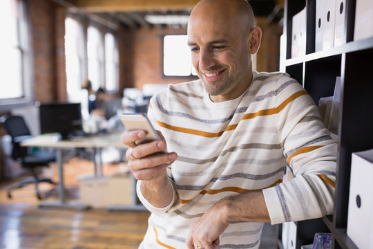 Businessman Using Cell Phone In Office