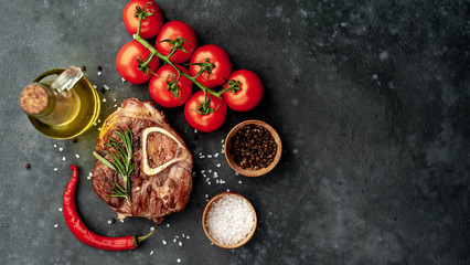 grilled steak, with tomatoes and spices on a stone background with copy space for your text