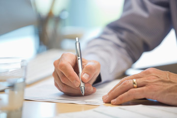 Businessman writing on document at desk