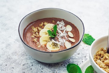 Chocolate smoothie bowl topped with fruits and seeds/ Healthy breakfast concept
