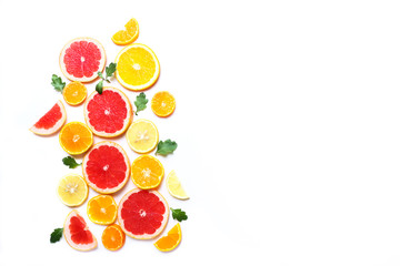 Slices of oranges, grapefruits and tangerines on white background. Top view