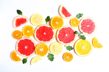 Slices of oranges, grapefruits and tangerines on white background. Top view