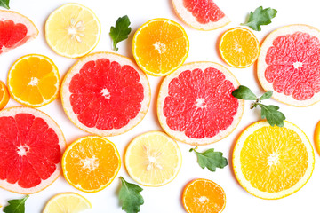 Fototapeta na wymiar Slices of oranges, grapefruits and tangerines on white background. Top view