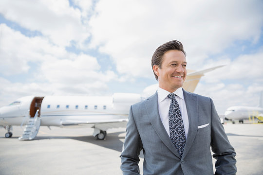 Businessman on tarmac with corporate jet