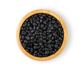 Black bean seeds in a wooden bowl isolated on white background. Top view
