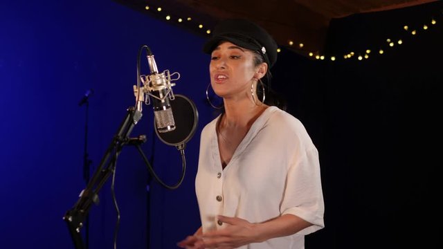 Female Singer / Popstar recording  Album in the studio - She sings into the Microphone. Vocalist singing a song. Pan up