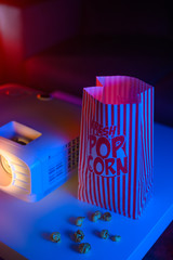 Concept of relaxing and watching movies. Projector and popcorn. Home cinema. Vertical shot.