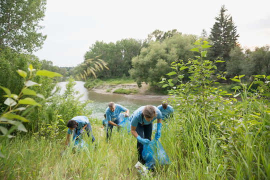 Volunteers picking up garbage in field