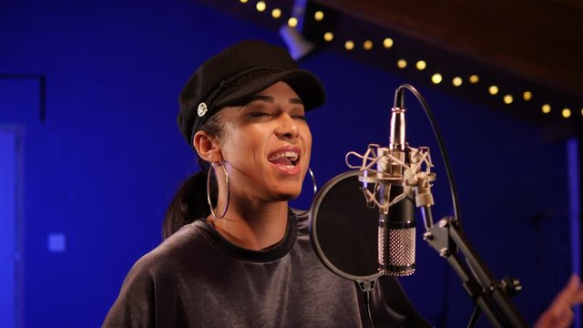 4K: Female Singer / Popstar recording an Album in the studio - She sings into a Microphone. Vocalist singing a song