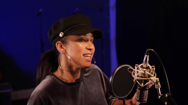 4K: Female Singer / Popstar recording an Album in the studio - She sings into Microphone. Vocalist singing a song