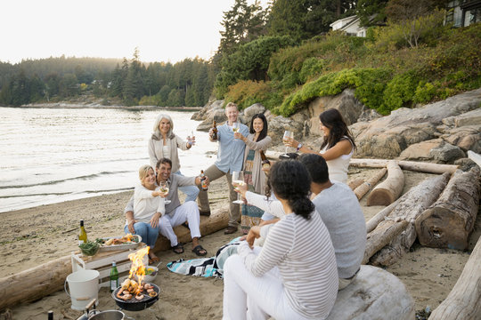 Friends Enjoying Clam Bake On Beach