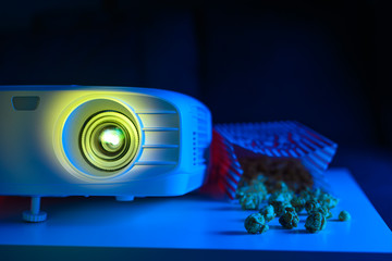 Projector for watching movies for home, or a movie theater with popcorn on a dark background