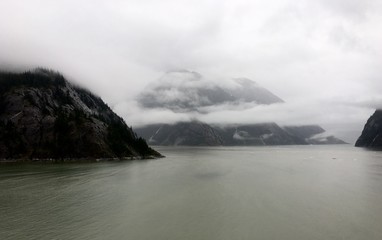 Fototapeta na wymiar mountains along water covered in fog