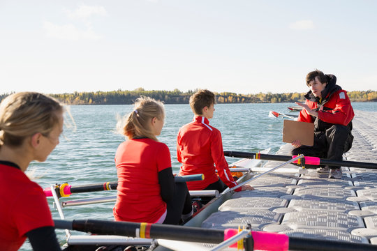 Coach Talking To Rowing Team In Scull