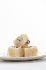 Delicious white fudge piled on a plate with white background