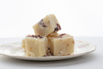 Delicious white fudge on a plate with a white background