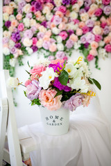 Interior in the style of French Provence. White bucket with colorful flowers ev a white whatnot. Close-up. Selective focus