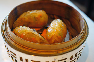 Dish of steamed Chinese dim sum dumplings in a silver and bamboo steamer basket