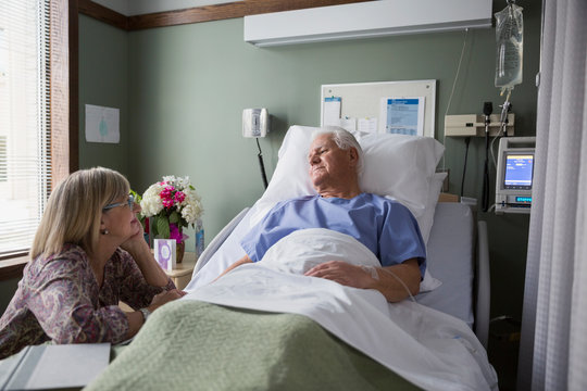 Wife talking to husband in hospital room