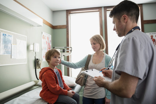 Male Nurse Talking To Boy In Examination Room