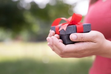 White ribbon gift box in hand for lovers on Valentine's Day