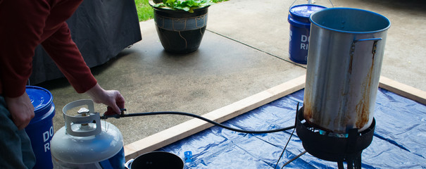 Man Adjusting Propane Burner For Deep Fried Turkey During Thanksgiving 