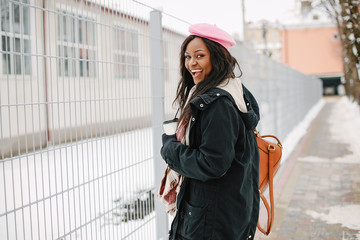 Cute black woman have fun in a city. Beautiful black girl in a pink beret.