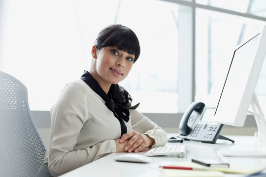 Portrait Of Businesswoman Sitting At Desk In Office
