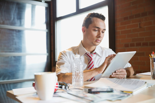 Entrepreneur working on digital tablet in creative office space