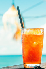 Orange ice sweet coctail on the ocean background with summer vibes