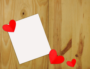 Heart shaped red paper on white paper on a wooden background Valentine's Day