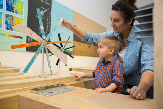 Mother Son Playing Metal Wind Turbine Science Center