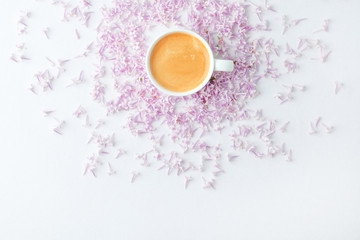 Obraz na płótnie Canvas Morning breakfast with coffee cup and lilac flowers on white background. Flat lay, top view women background. Minimal concept, wedding, valentine day, copy space