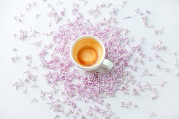 Morning breakfast with empty coffee cup, lilac flowers on white background. Flat lay, top view women background. Minimal springtime season concept, wedding, valentine day