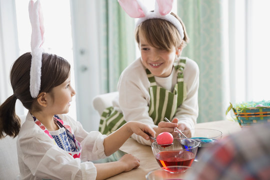 Siblings dyeing Easter eggs