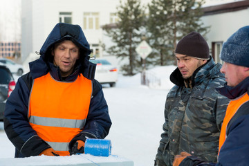 Three workers at the assembly site of the ice town