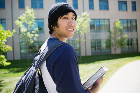 Portrait smiling college student in beanie on campus
