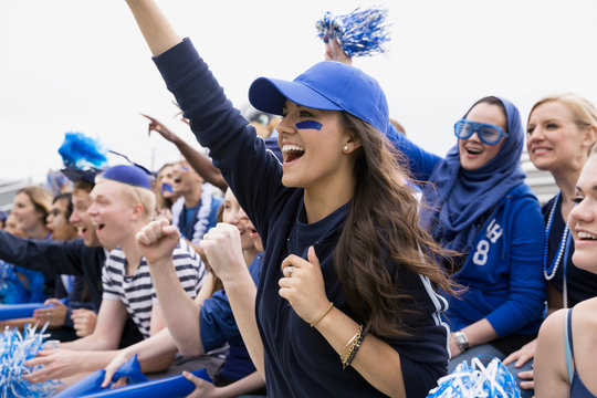 Cheering woman in blue in bleachers sports event