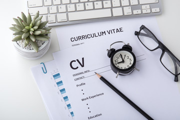 Curriculum vitae with clock on work desk - obrazy, fototapety, plakaty