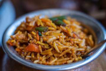 Navratan saffron biryani in metal pot on wooden background, top view, close up. Indian cuisine