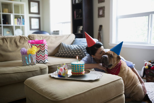 Woman and dog celebrating birthday with cake
