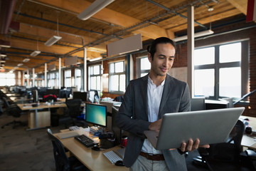 Businessman using laptop in open office