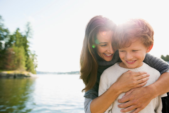 Mother Hugging Son At Sunny Lakeside